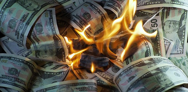 US dollar bills burning in bright flames